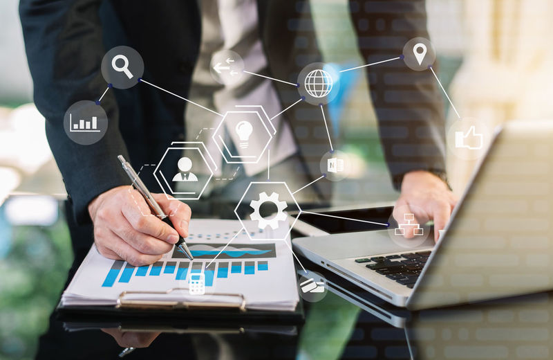 Digital composite image of businessman using laptop