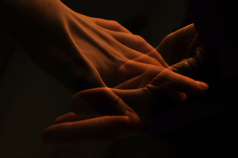 Double exposure of hand holding against black background