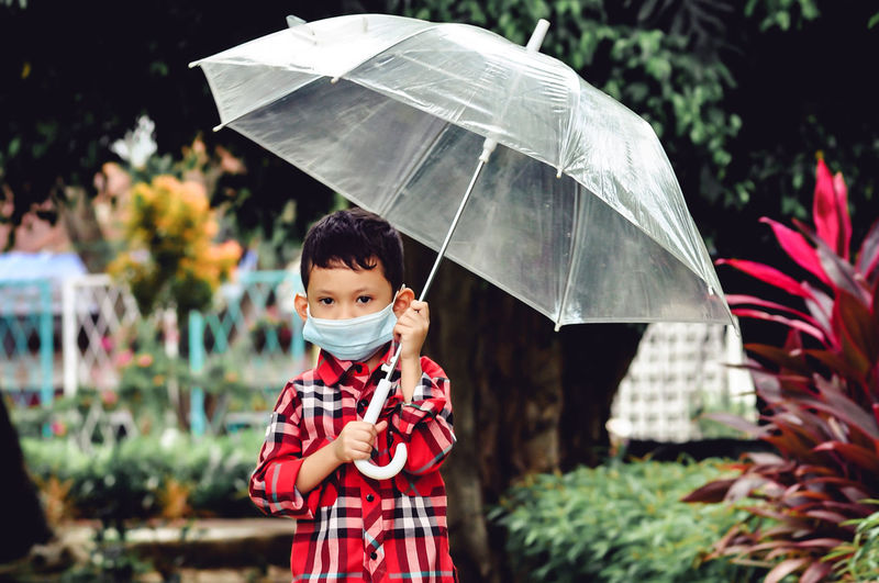Portrait of boy holding umbrella