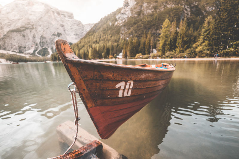 Boat moored on lake against mountain