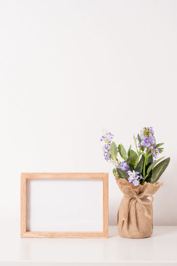 Flower vase against white wall