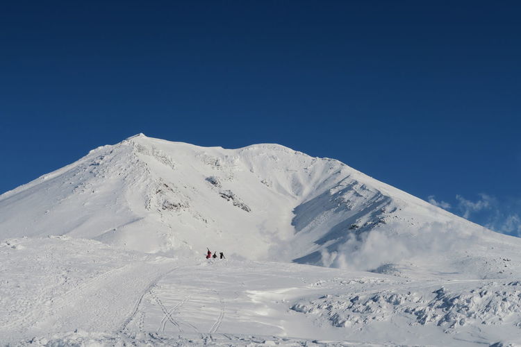 Scenic view of snowcapped mountains against clear blue sky