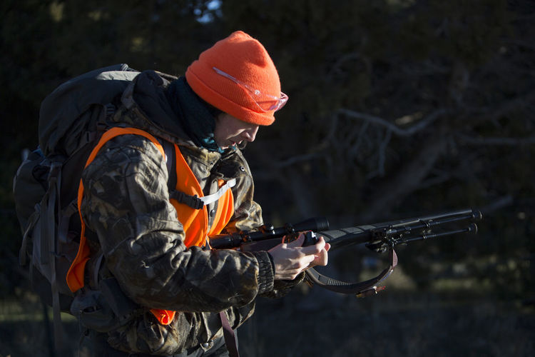 Female hunter loads her gun in paonia, colorado