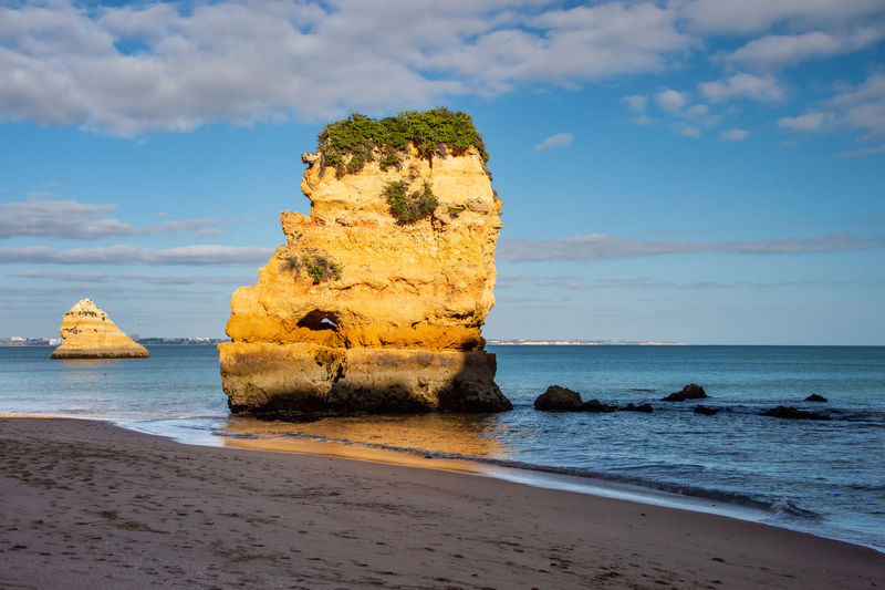 Rock formation on beach against sky