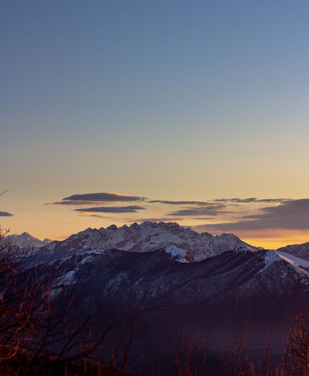 Scenic view of snowcapped mountains against clear sky during sunset