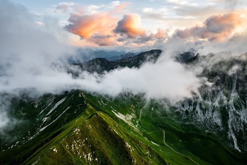 Scenic view of mountains and clouds against sky during sunset