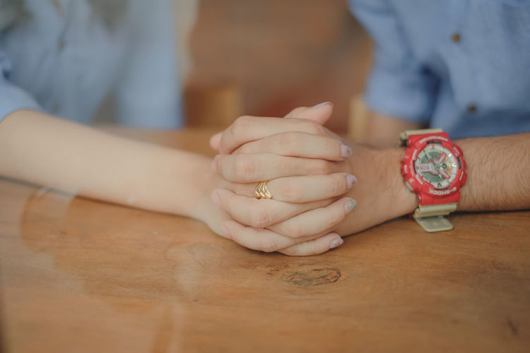 Close-up of woman holding hands on table