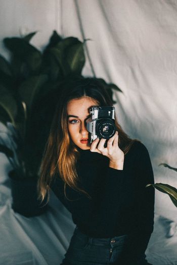 Portrait of young woman photographing