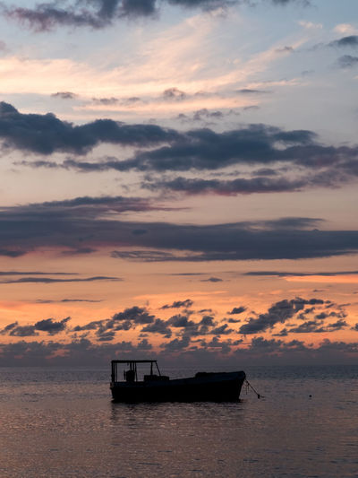 Silhouette boat on sea against sky during sunset