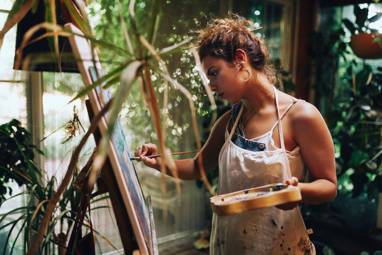 EyeEmNewHere EyeEm Best Shots Adult Beautiful Woman Casual Clothing Day Front View Hairstyle Holding Leisure Activity Lifestyles Looking One Person Outdoors Painter - Artist Plant Real People Standing Three Quarter Length Waist Up Women Young Adult Young Women