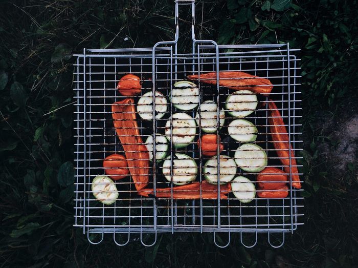 Directly above shot of vegetables in barbecue grill on field