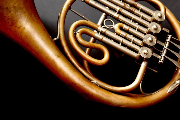 Close-up of french horn against black background