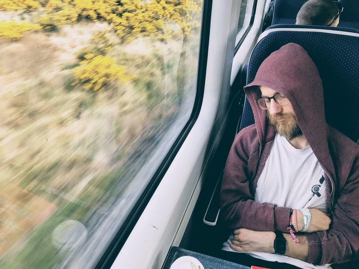 High angle view of man sleeping while traveling in train