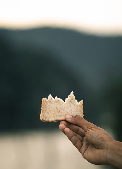 The bread in the hand that has been bitten