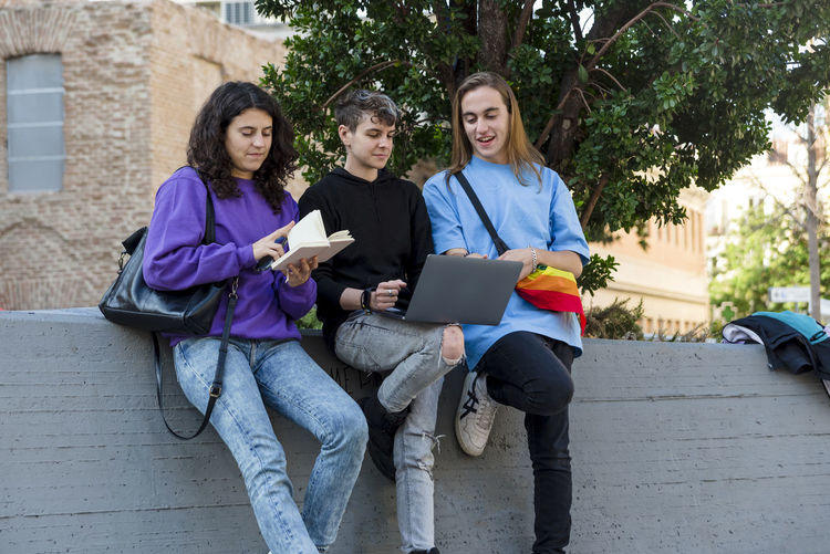 Portrait of smiling friends using digital tablet