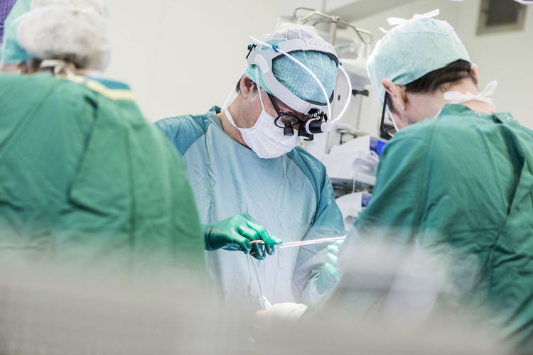 Heart surgeons and operating room nurse during an operation