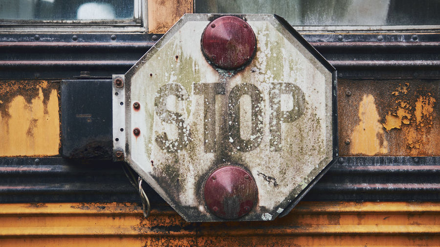Close-up of old rusty sign of a school bus