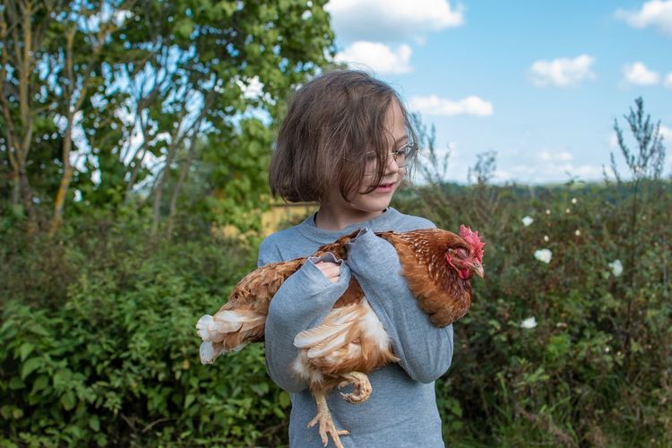 A child holding a hen