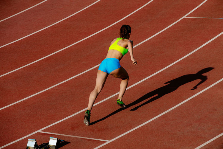 Full length of woman running on race track
