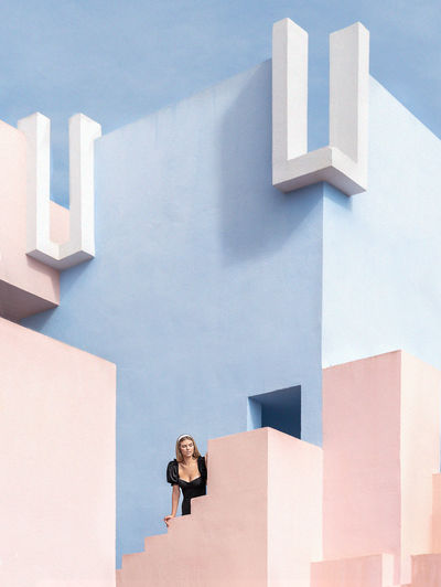 Woman standing on staircase against building