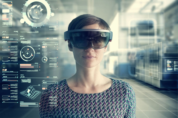Woman wearing mixed reality smartglasses at transparent screen