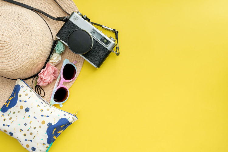 High angle view of personal accessories on yellow background