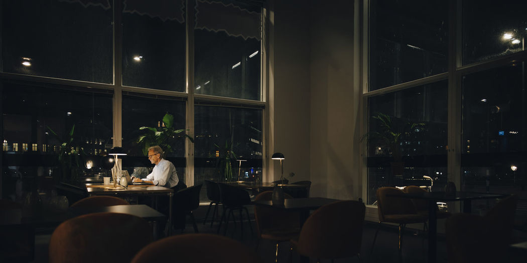 Man sitting at restaurant table at night