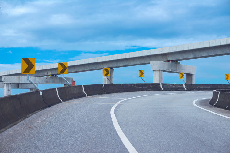 Road by bridge against sky