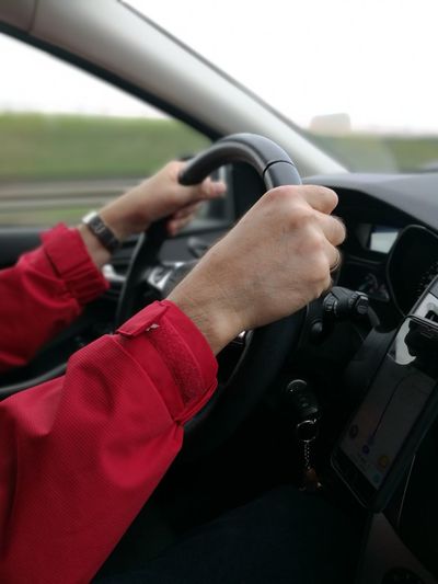 Cropped hands of person driving car