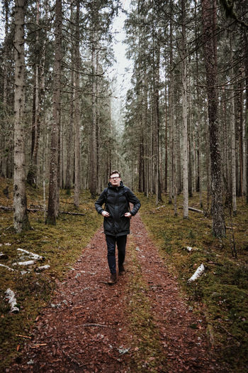 Full length of man standing on footpath in forest