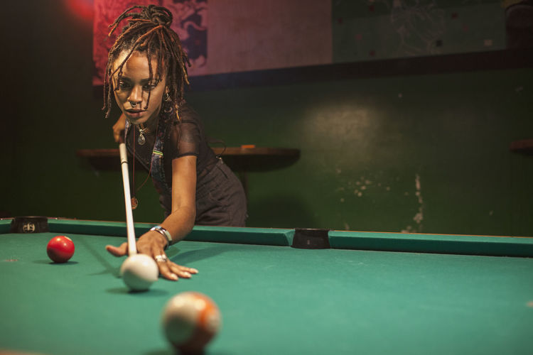 A young woman playing pool.