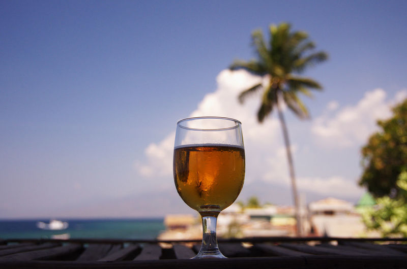 Close-up of beer in glass against sky