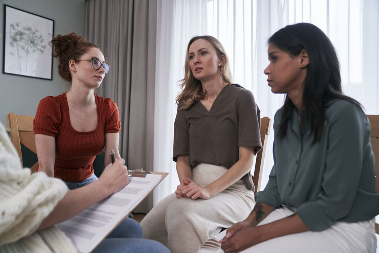 Woman with friends talking to psychotherapist