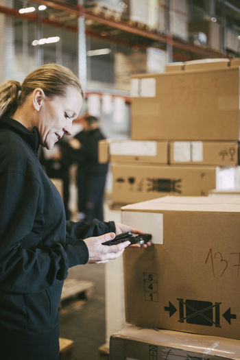 Female entrepreneur scanning with bar code reader at logistics warehouse