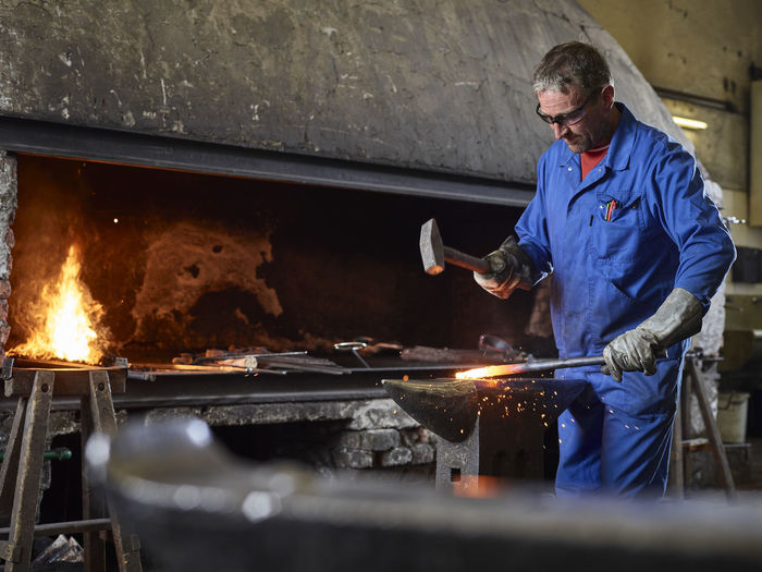 Blacksmith hammering hot iron