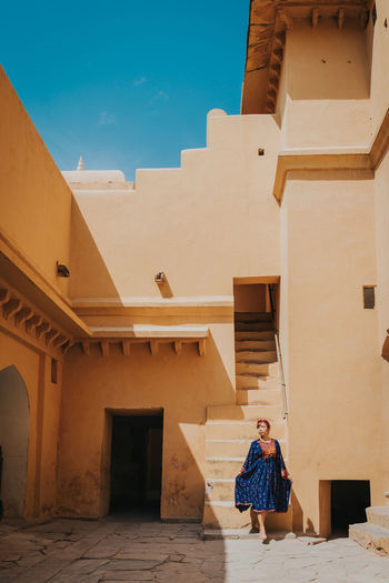 Woman standing against building