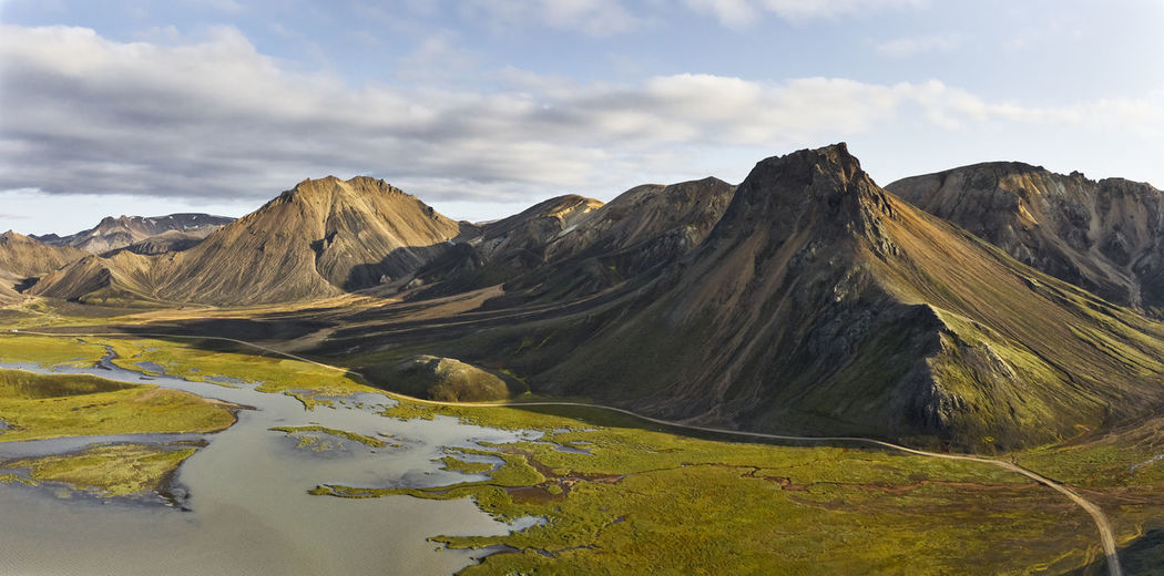 Road between mountains and wetland