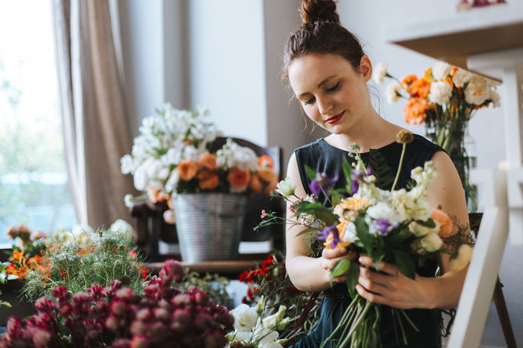 Woman arranging flowers in shop
