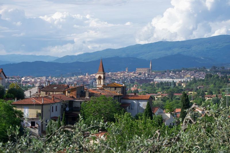 Scenic view of a village in countryside on background of arezzo town, on springtime