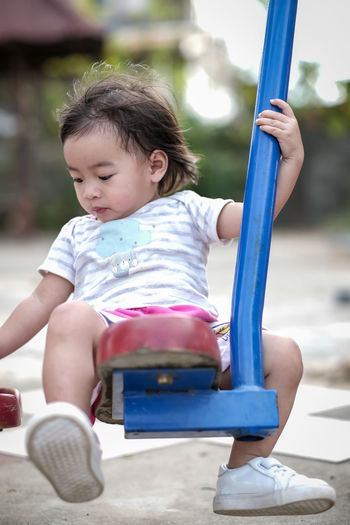 Cute girl sitting on slide at playground