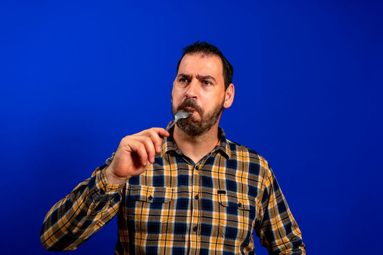 Man standing against blue background