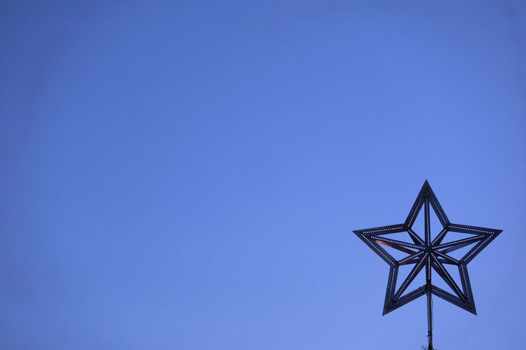 Low angle view of windmill against clear blue sky
