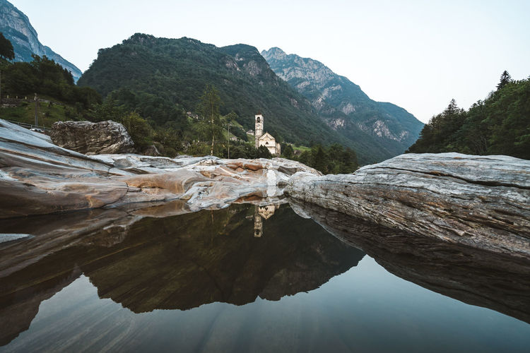 Small town chapel reflected in the calm waters of valle verzasca.