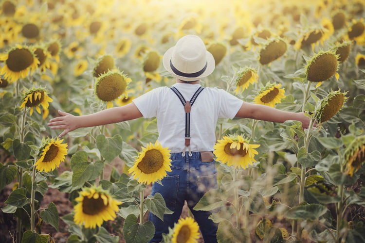 Low angle view of woman standing on sunflower field