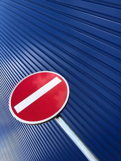 Low angle view of road sign by wall