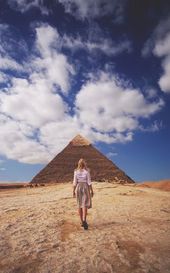 Woman walking on landscape against sky