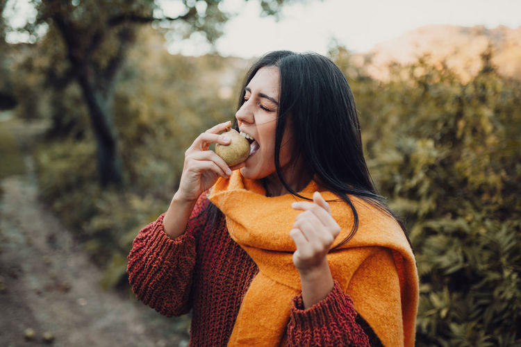 Young woman holding ice cream cone outdoors