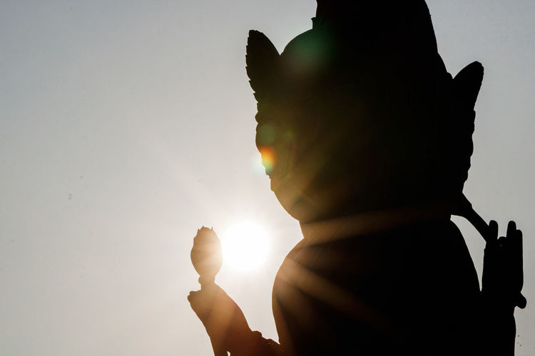 Low angle view of silhouette statue against sky during sunset