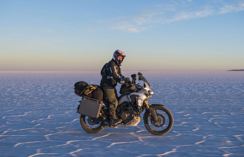 Man riding his touring motorbike on the salt flats of uyuni in bolivia
