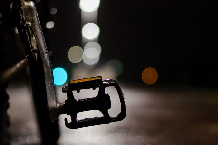 Cropped image of bicycle pedal at night